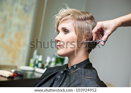 attractive woman in hair salon with cut hair on her shoulder