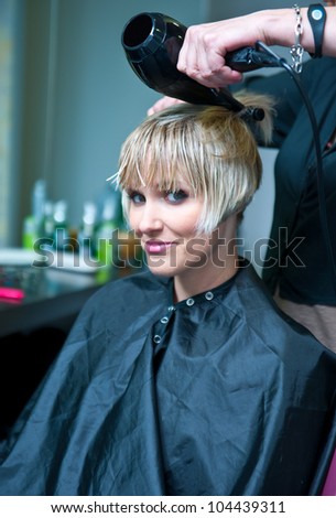 attractive woman drying her wet hair in hair salon