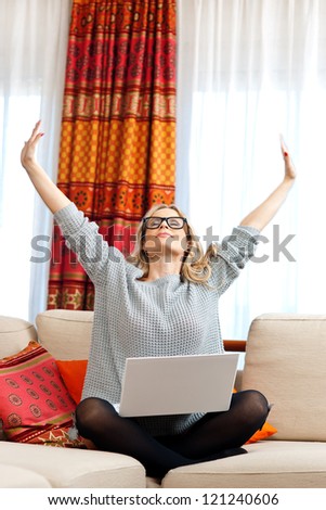 attractive woman sitting with laptop and stretching her arms