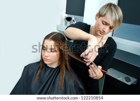 hair stylist making new haircut to brunette woman in salon