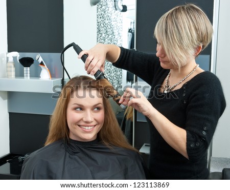 hair stylist making new haircut to brunette woman in salon