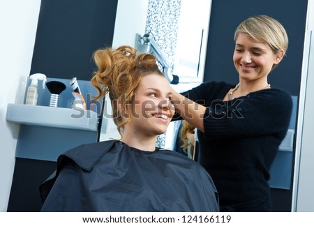 hair stylist working on woman hair in salon