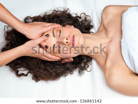 attractive woman on massage table in beauty salon having chiropractic neck adjustment