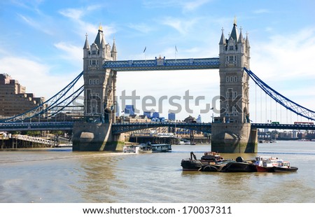 LONDON , ENGLAND - SEPTEMBER 16 ,2009: boat crossing beneath  London Bridge over the River Thames in central London.
