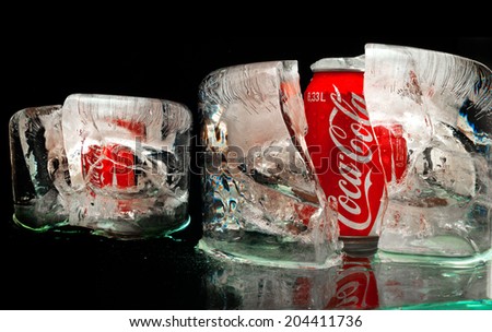 ZAGREB , CROATIA - JANUARY 24 ,2014 :   coca-cola can splashed with water in block of ice on black background, product shot