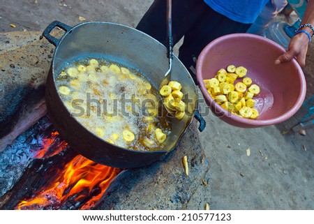 fried plantains banana in pan on open fire preparation