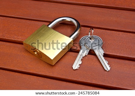 Padlock with keys on the wooden table