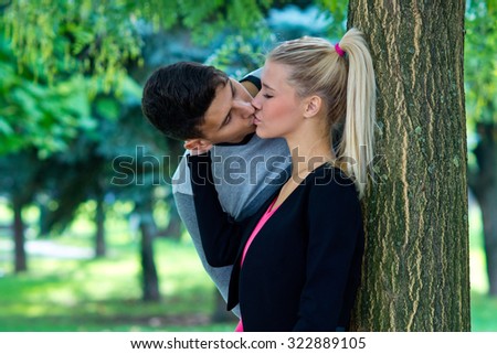young happy couple in love kissing and hugging outside