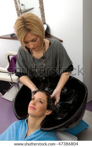hair stylist washing woman hair in salon