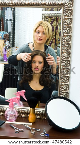 hair stylist work on happy woman hair in salon