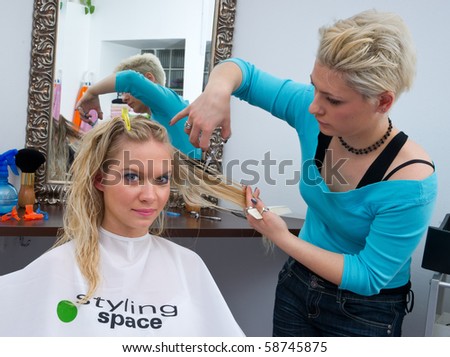 stylist cuttings woman hair in salon