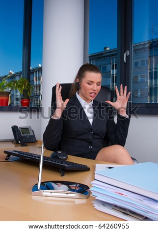 upset business woman in office with wireless headset talking