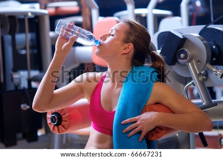 woman in gym drink water after exercise