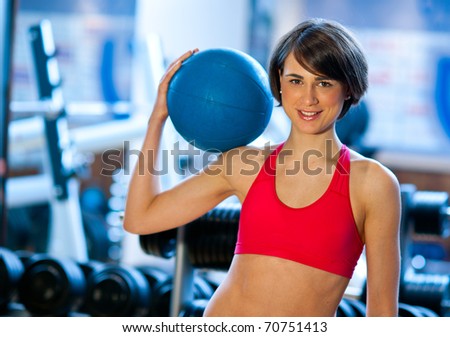 woman in gym relaxing with medicine ball
