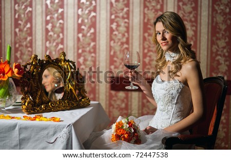 bride in wedding dress with glass of wine