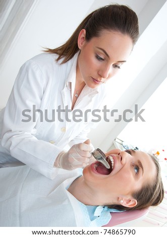 dentist using dental impression tray on woman teeth