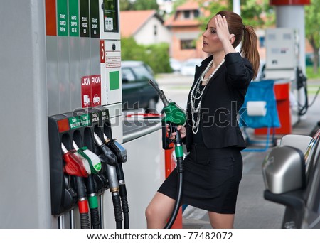 unhappy elegant woman looking price on gas station