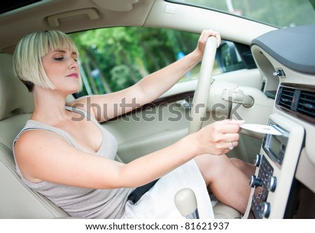 attractive woman changing cd and listen music on car radio