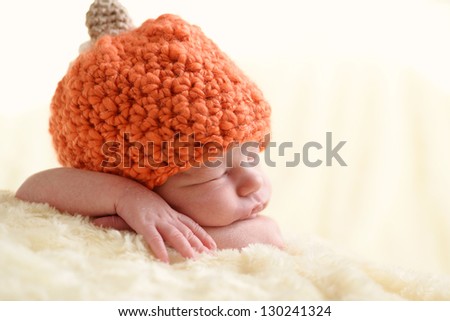 sweet  newborn wearing pumpkin hat