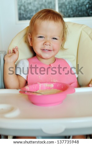 happy eating baby girl in chair