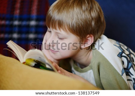 boy reading  a book at home