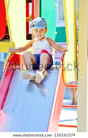 cute toddler on the slide on  playground
