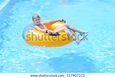 funny boy on ring in the pool