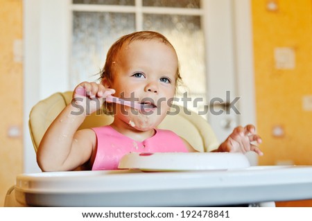 happy eating baby with spoon in mouth