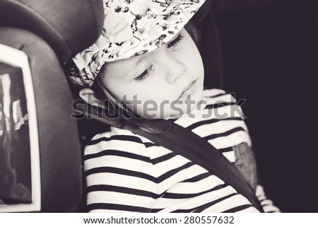 tired little girl in the car seat
