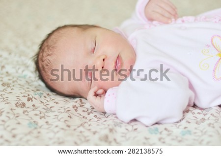 sleeping sweet newborn girl on the bed