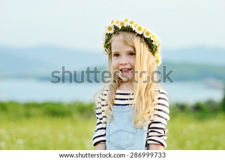 happy girl in field with a garland on the head