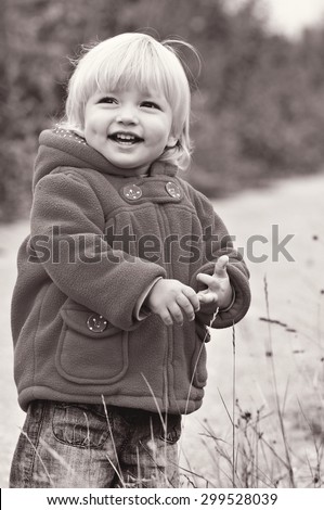 cute laughing toddler girl in fall park