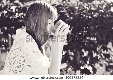 girl with mug of hot drink in sunny fall day