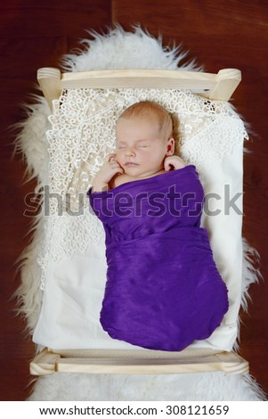 sweet newborn baby sleeping in the little bed