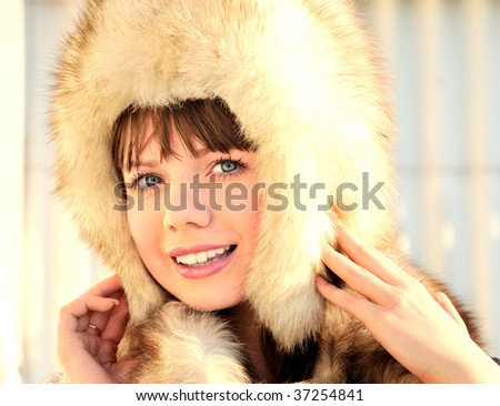 pretty girl with blue eyes is wearing winter fur cap