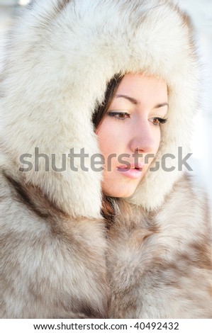 Pretty brunette with hazel eyes is wearing winter fur cap