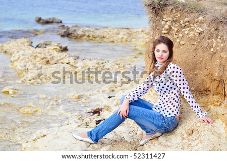 teen romantic girl wearing spotted blouse on the sea coast