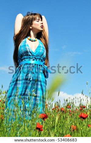 spring beautiful woman relaxing on the poppy meadow