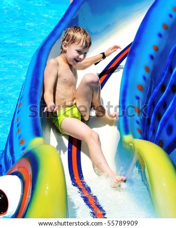 little boy sliding down a water slide  and having fun