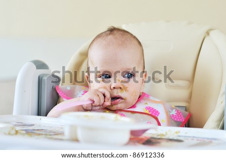 first meal of six months baby on her face and everywhere
