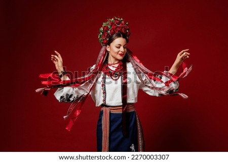 Portrait of ukrainian woman in traditional ethnic clothing and floral red wreath on viva magenta studio background. Ukrainian national embroidered dress call vyshyvanka. Pray for Ukraine Stockfoto © 