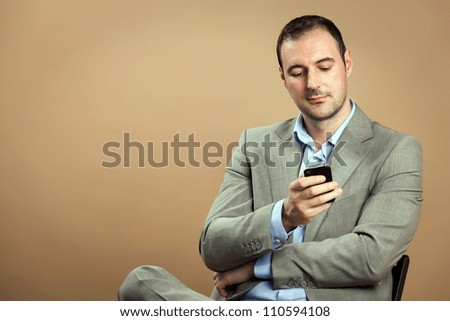 Relaxed man wearing classic business outfit while is making a phone call.