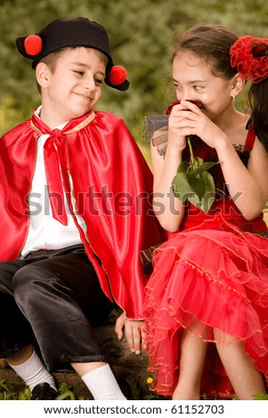 Portrait of a very young couple in spanish style garment having fun in a meadow. More images with the same models.