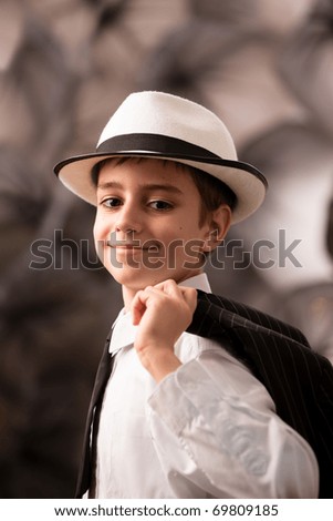 Portrait on a lovely boy with attitude in a black tuxedo with shirt and tie. See other images.