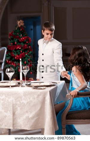 Lovely young couple having dinner in a romantic restaurant in Christmas time. Please see more images from the same shoot.