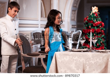 Lovely young couple having dinner in a romantic restaurant in Christmas time. Please see more images from the same shoot.