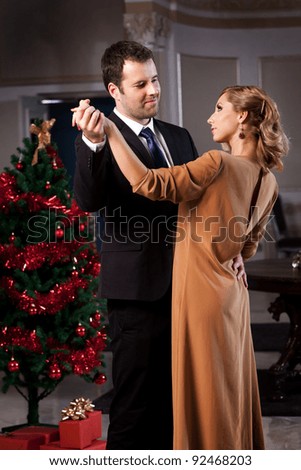 Lovely young couple dancing in a romantic restaurant in Christmas time. Please see more images from the same shoot.
