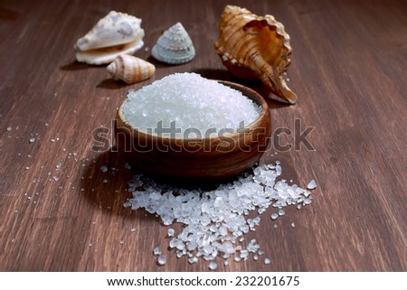 Sea salt crystals and shells on wood background