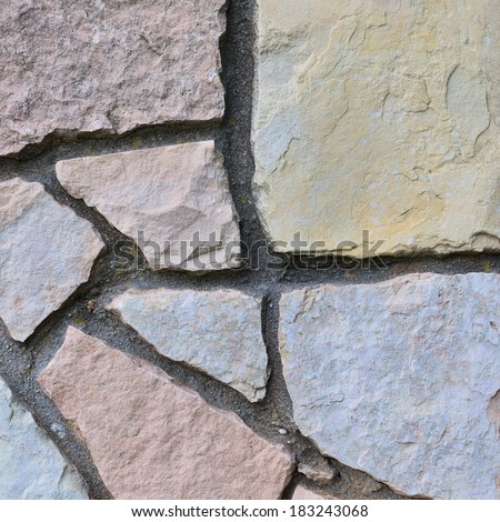 Stone fence background, stonewall closeup, decorative limestone dolomite hard sedimentary slate slab rock texture pattern, textured natural brick wall beige, grey, yellow, reddish, gray, red