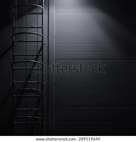 Fire emergency rescue access escape ladder stairway roof maintenance stairs night lantern lamp light shadows industrial building wall vertical closeup copy space background dark grey black